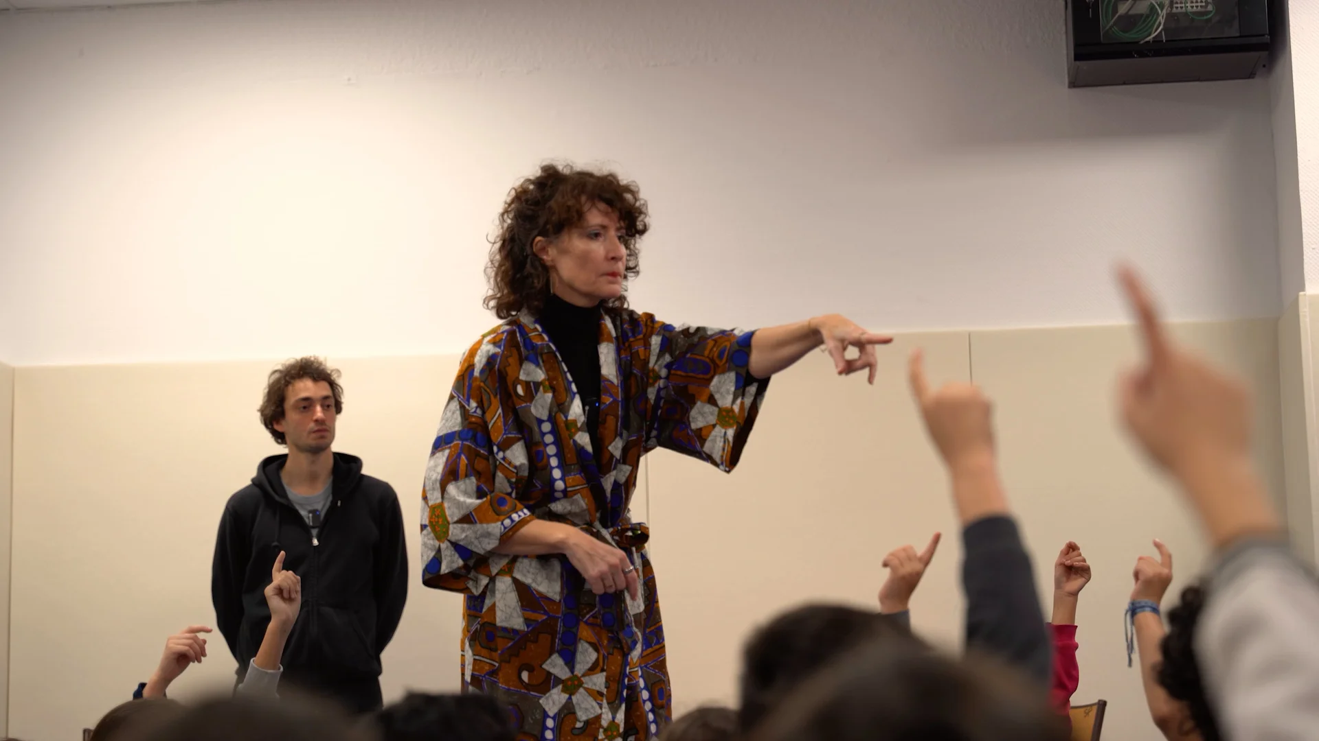 Béatrice désigne un élève parmi les mains levées, Samy en retrait - intervention scolaire