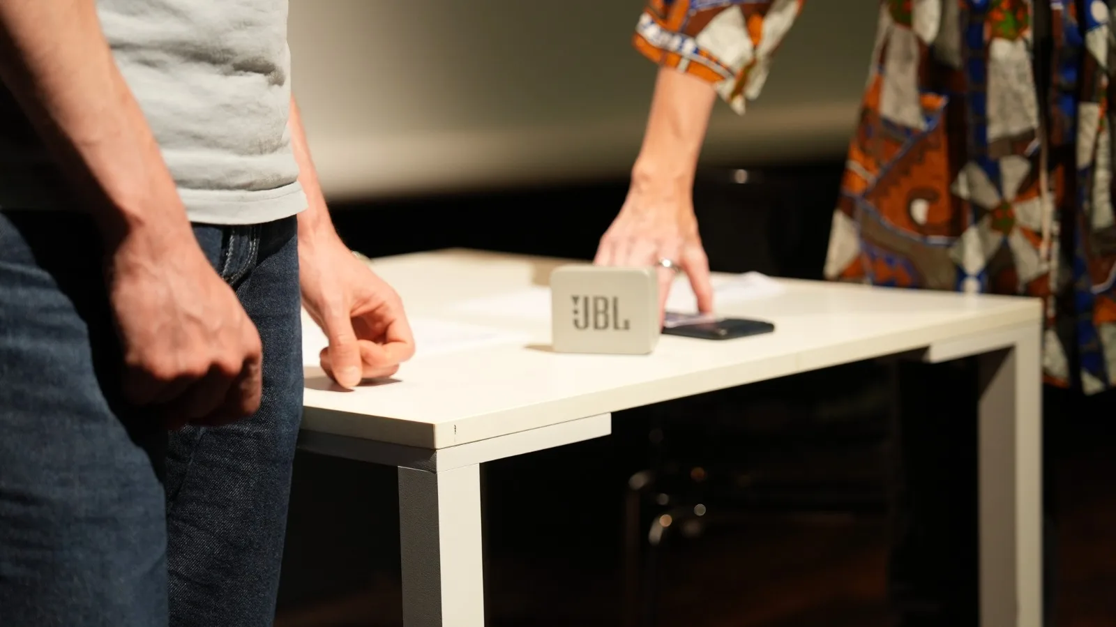Gros plan sur la table de scène : enceinte JBL et smartphone, accessoires du spectacle