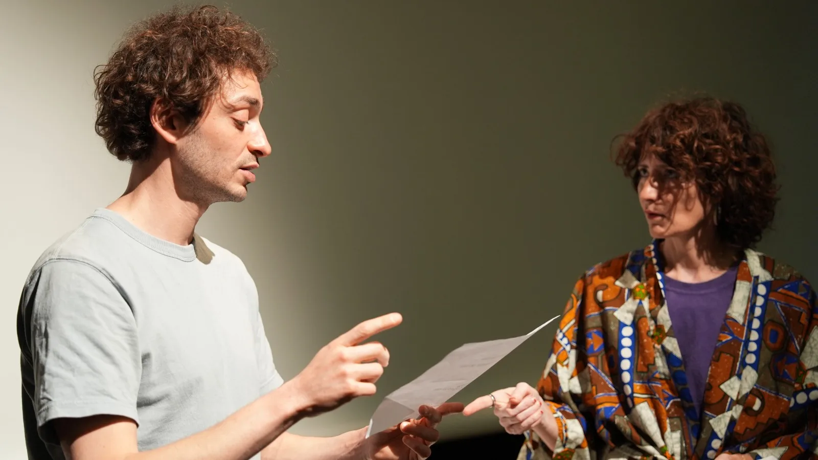 Samy lit un document face à Béatrice lors d'une répétition en studio